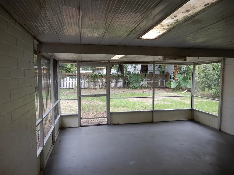 LARGE SCREENED IN PORCH IN THE REAR OVERLOOKING FENCED-IN BACKYARD.