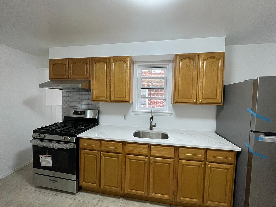 Kitchen with new fridge, stove with oven, and hood