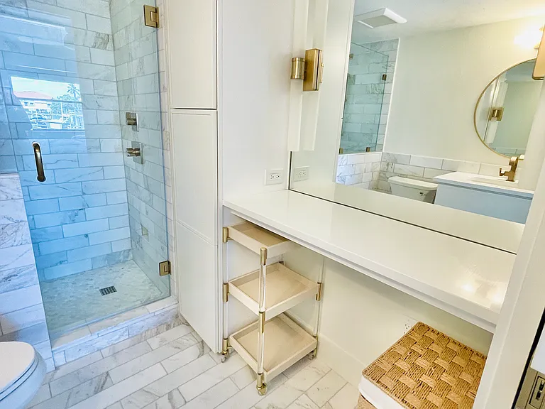 Primary bathroom with glass shower enclosure and make up vanity