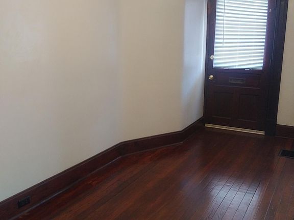 large foyer with hardwood floor; could be a place for a desk, table or sofa