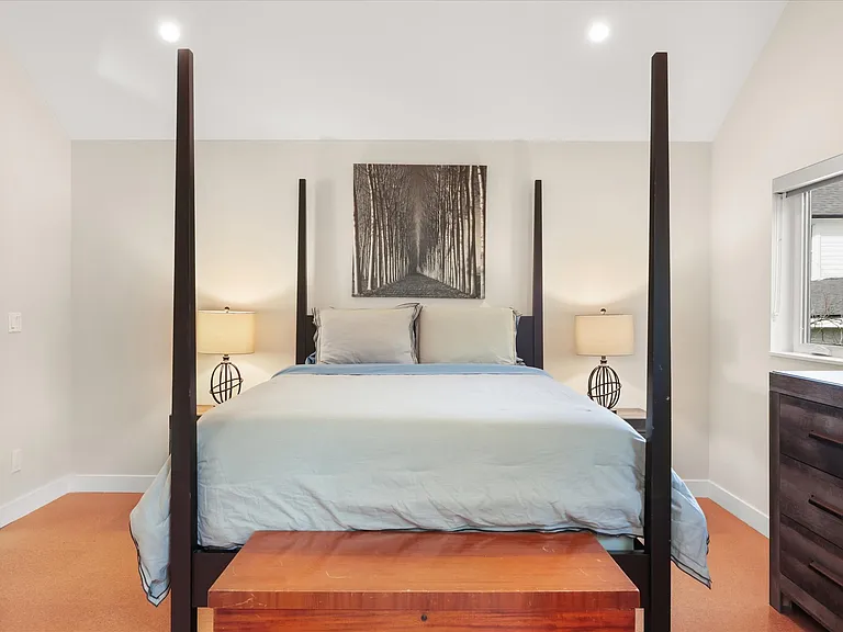 Bedroom with treetop views and high ceilings.
