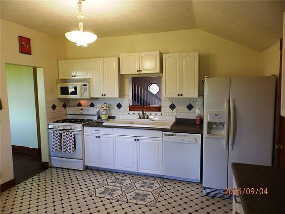 Kitchen has hand painted Mexican tiles & backsplash, W/I pantry, cast iron/ceramic vintage sink.