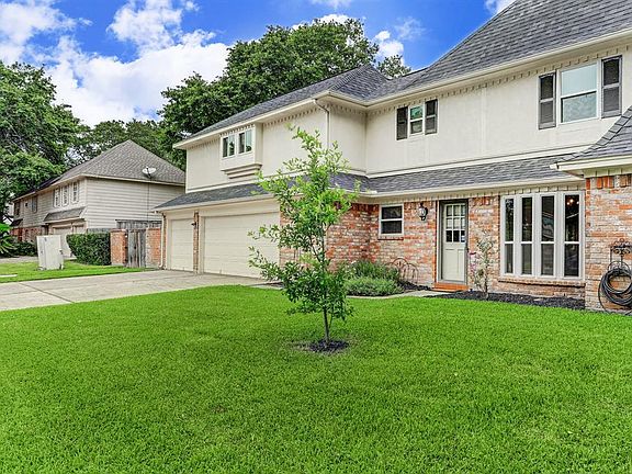 View of side of home looking from Champion Drive. Oversized three car garage with wash up sink.