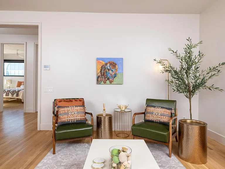 Inviting living room with a comfy couch, two chairs, flat-screen TV, and a stylish bar cart_perfect for relaxing or entertaining.
