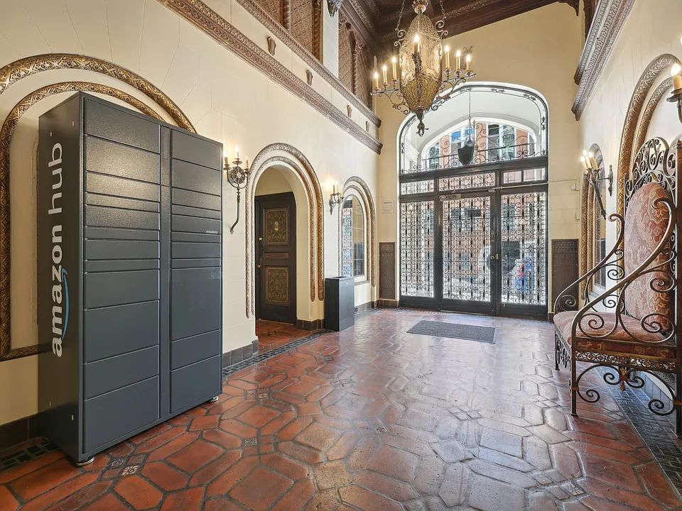 Elegant building entrance with ornate decor, Amazon Hub locker, tiled floor, wrought iron fixtures