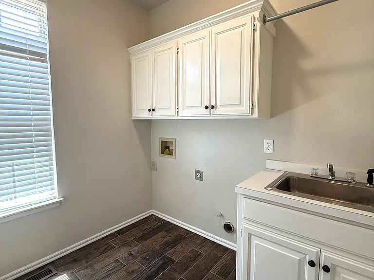 Laundry room with large sink. Room strategically placed next to kitchen and near the garage door to not track mud through the house.
