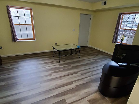 Large sized living room with 2 windows, a lot of natural air and light. TV with TV stand is included. Leads into the backyard.