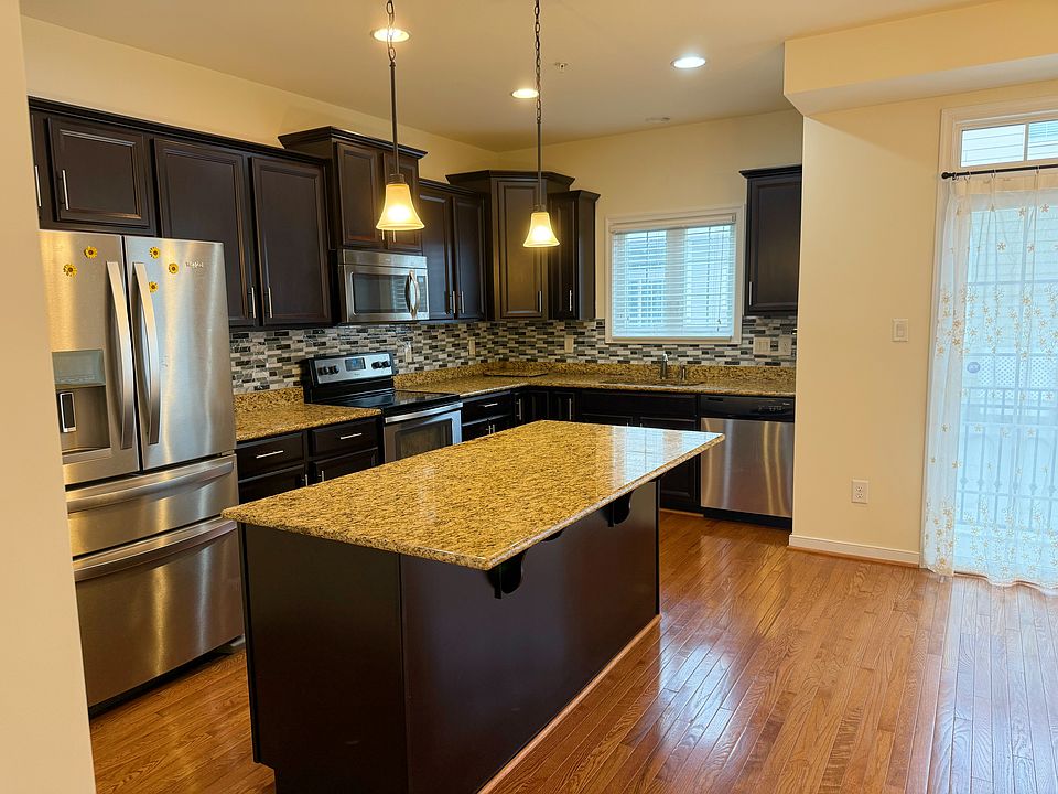 Modern kitchen with granite countertops, center island, and stainless steel appliances
