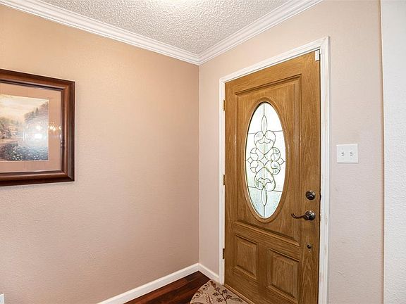 The front door has a lovely leaded glass pattern that leads to the entryway with decorative crown molding.