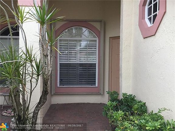 Covered Front door entry, note accordion shutters which are all windows, and sliding doors