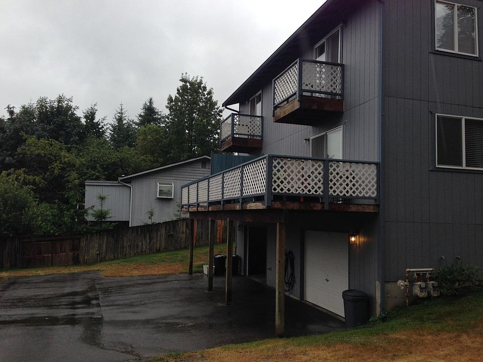 Back view shows large deck off living room and balcony off M