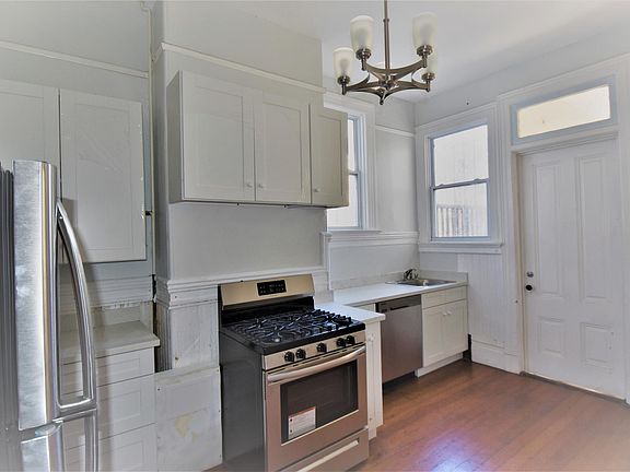 kitchen with stainless steel appliances, quartz countertop and white shaker style cabinetry