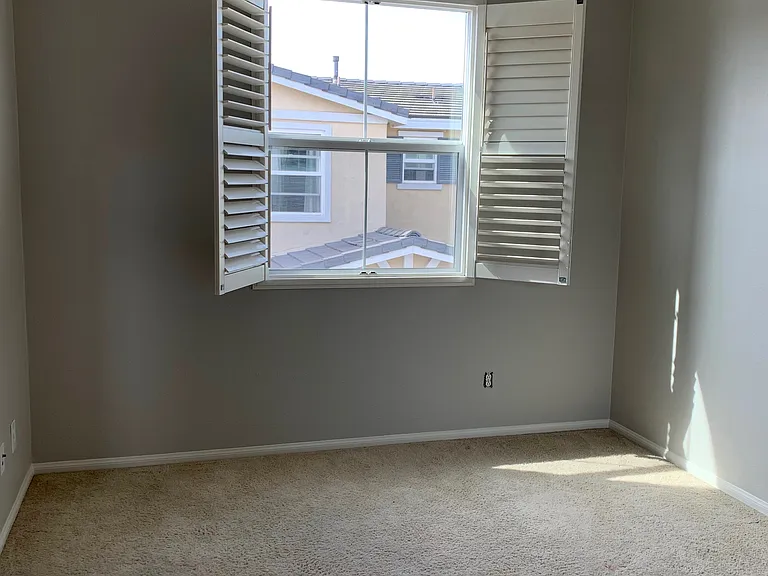 View from the doorway looking into the room with view and ceiling fan.