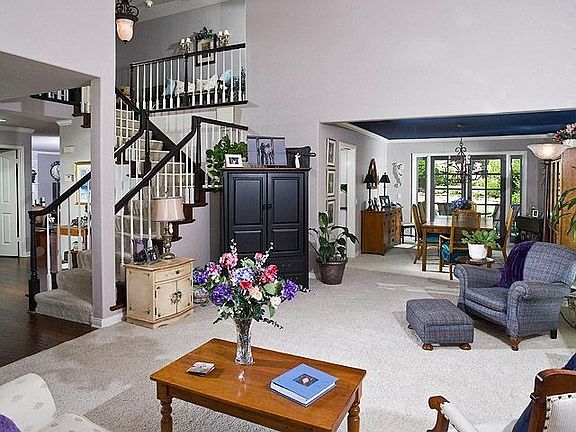 Formal entry with vaulted ceilings and sweeping staircase