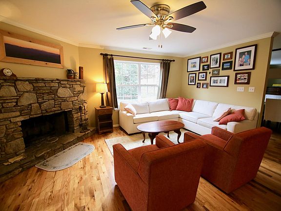 Living room with stone fireplace, swivel chairs and sectional sofa