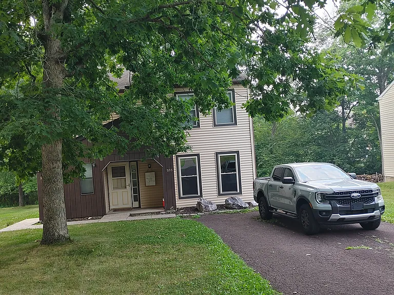 Front yard, with off-street parking for two cars. The house is rather hidden, so see the 2012 photo (next where the greenery is not so dense)
