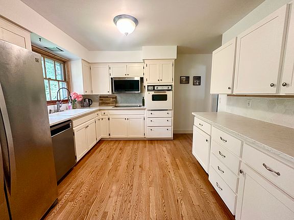 Main kitchen features a newer washer, electric cooktop, side-by-side fridge and freezer, and an old oven that still works perfectly.