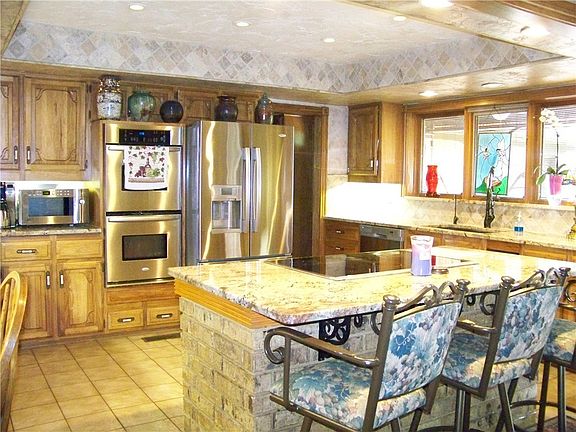 Stainless Steele appliances and Refrigerator stays, Stove top has an electronic vent hood that rises out of the countertop; Microwave is excluded