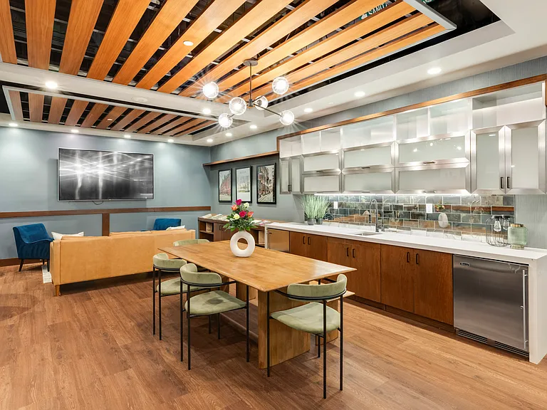 Relax in the resident lounge featuring wall-mounted TVs, fireplace, and kitchenette