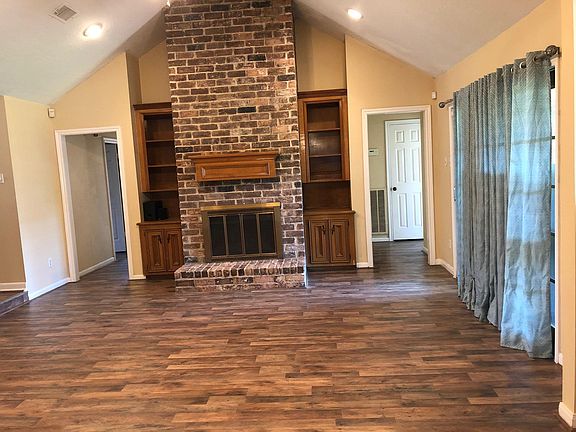 Fireplace in the spacious living room with newly installed hardwood floor.