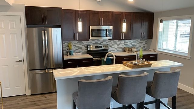Kitchen / Bar Area showing Stainless Steel appliances, solid cherry cabinets and quartz countertops.