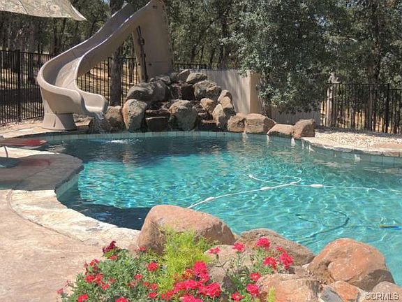 Fenced, low maintenance saltwater pool with waterfall and slide