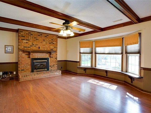 Spacious family room with brick fireplace and gas logs.
