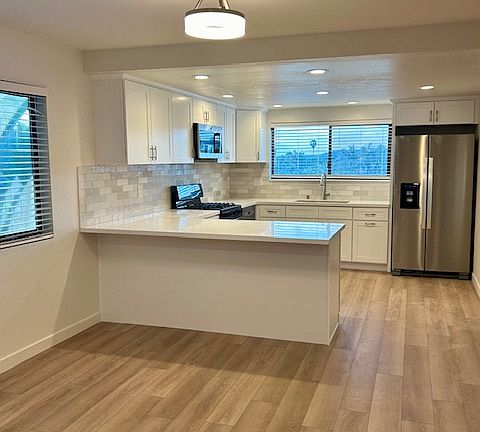 Kitchen with refrigerator, dishwasher, microwave, gas range. Counter counter tops and custom backsplash. Bar counter top eating area plus dining room. New waterproof flooring, recessed ceiling lighting