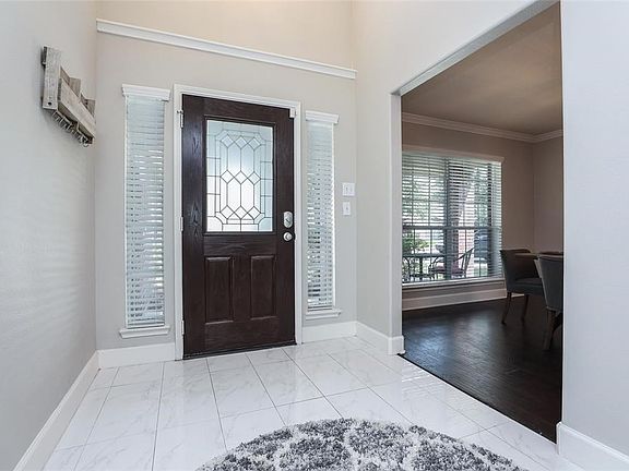 Tiled Entry with a lead glass front door, side lights and a decorators niche.  Notice the 2" baseboards.