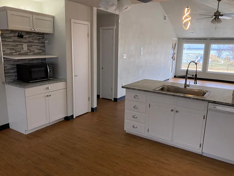 Note microwave / coffee bar. There are hooks for cup and a rack for stem wine glasses. A little extra?