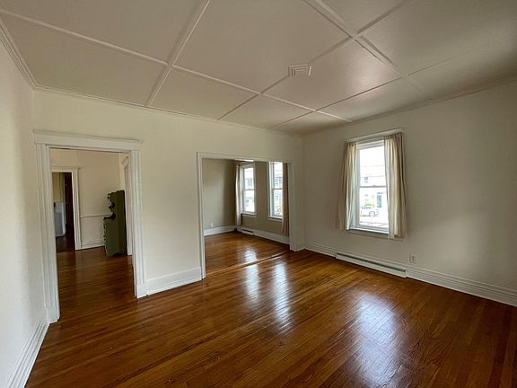 Living room looking into other common room and dining room