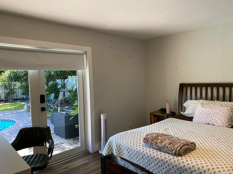 Private bedroom with a full bed and desk area, plus sliding glass doors offering direct access to the backyard patio.