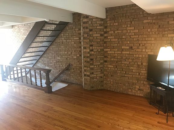 brick wall living room, stairs from garage & to bedrooms
