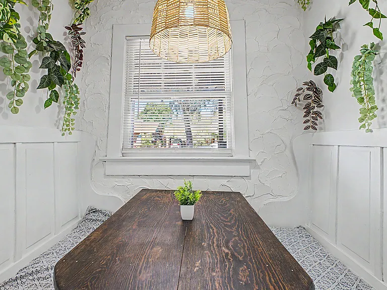 Dedicated dining nook with built-in bench seating, a wood table, and a window with blinds for everyday meals or work.