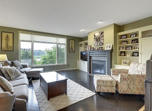 Great room seating area is defined by a stylish color change in the beautiful hardwood floors