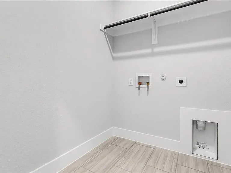 Dedicated utility area featuring wood-finish tile flooring, white baseboards, and light gray wall paint