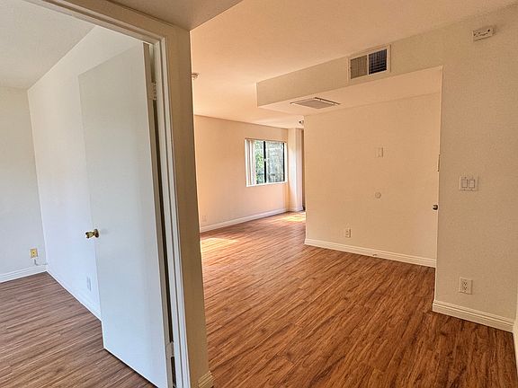 view looking in bedroom (l) and main living and dining areas (taken from area outside bedroom and bath)