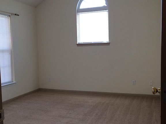 Master bedroom with vaulted ceiling, ceiling fan and large closet with built in shelving.