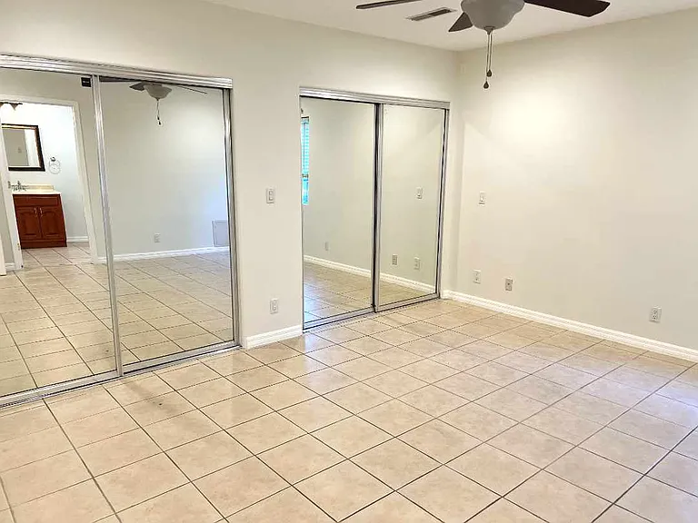 Primary bedroom with dual lit closet areas.