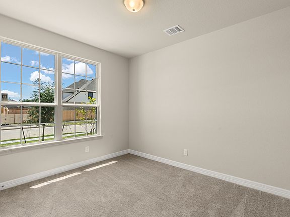 Perfect for an in-law suite, the fourth bedroom located on the first floor features plush carpet, la