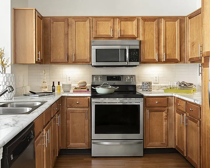 Apartment Kitchen with Stainless Steel Appliances, quartz counters and wood floors.