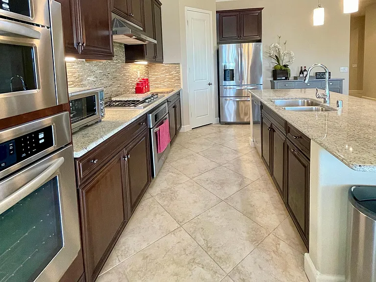Fully stocked Chef's kitchen including stainless double ovens, built-in microwave, gas six-burner cooktop, Breville counter oven, vent hood, dishwasher, under-mount double basin sink and French door refrigerator all topped with granite counters.