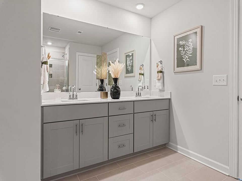 The primary bathroom boasts dual-sinks and an oversized mirror.