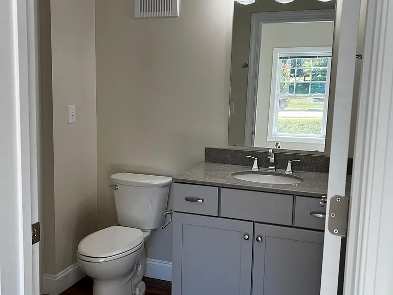 Master Bath has vanity with a stone top and a walk-in shower with a shower seat.