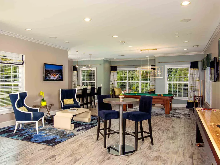 Entertainment lounge with pool table, games, and TVs