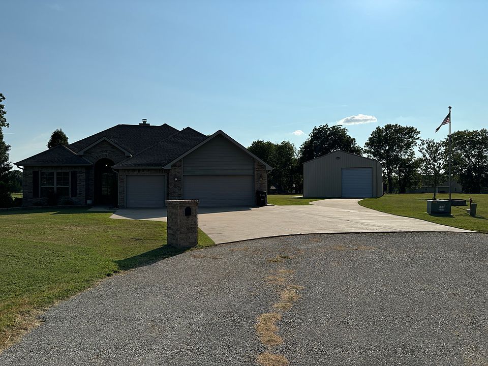 Front of property with huge driveway and flagpole. Attached 3-car garage.