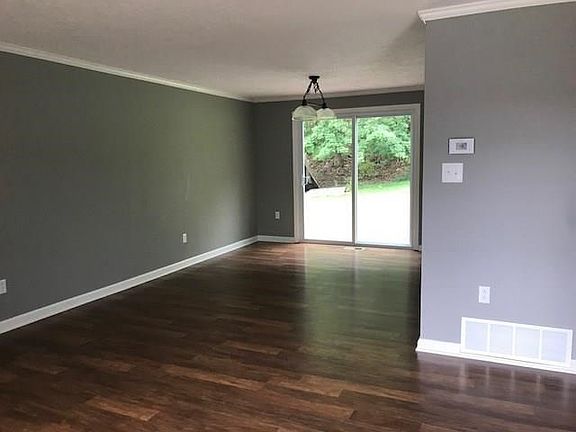 A view from the living room into dining room. Notice the brand new floors and sliding glass door that leads onto new deck.