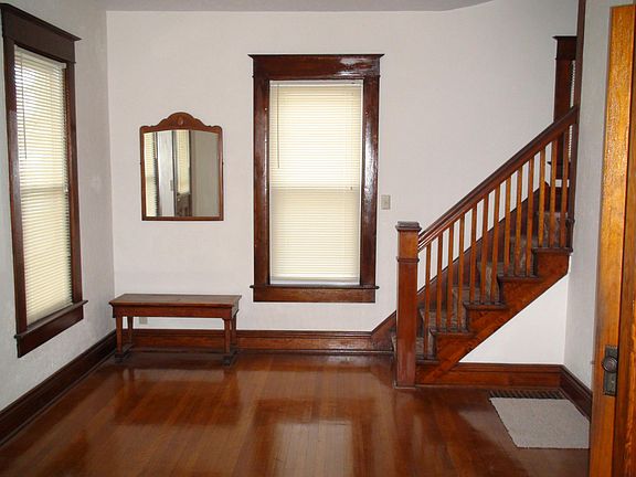 Entry foyer. Front entrance door to the left and entry into the kitchen at the right. A stairway in the 2nd floor is shown. There is also a stairway acces to the 2nd floor from the kitchen.