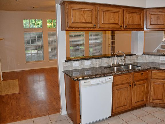 Family room and kitchen look out on deck and tree shaded back yard.