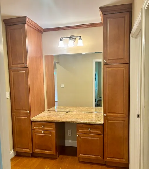 Granite Desk/Vanity with maple cabinetry and storage towers on both sides.